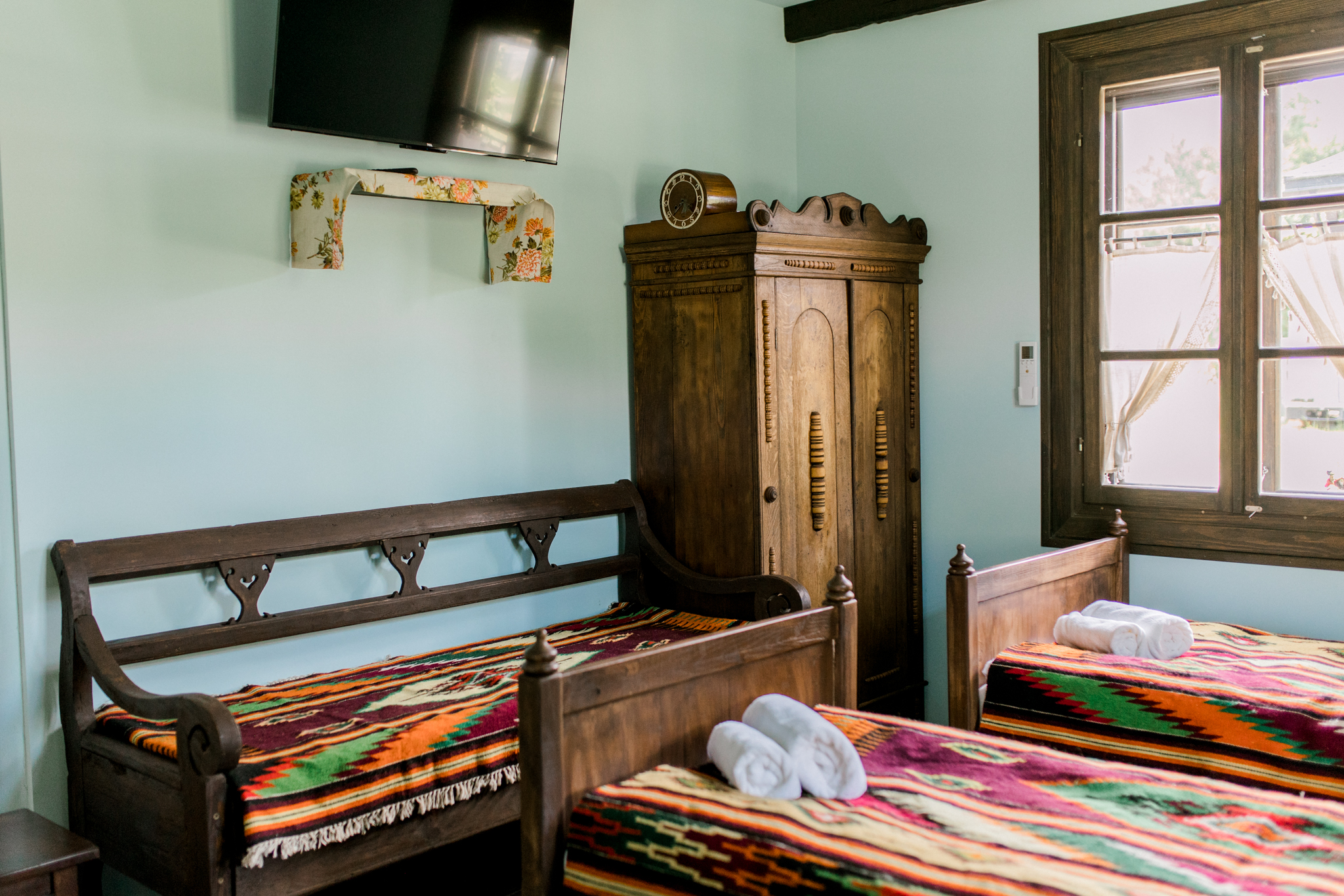 Przytulny pokój gościnny z drewnianymi meblami i kolorowymi narzutami, noclegi w tradycyjnej chacie Polska