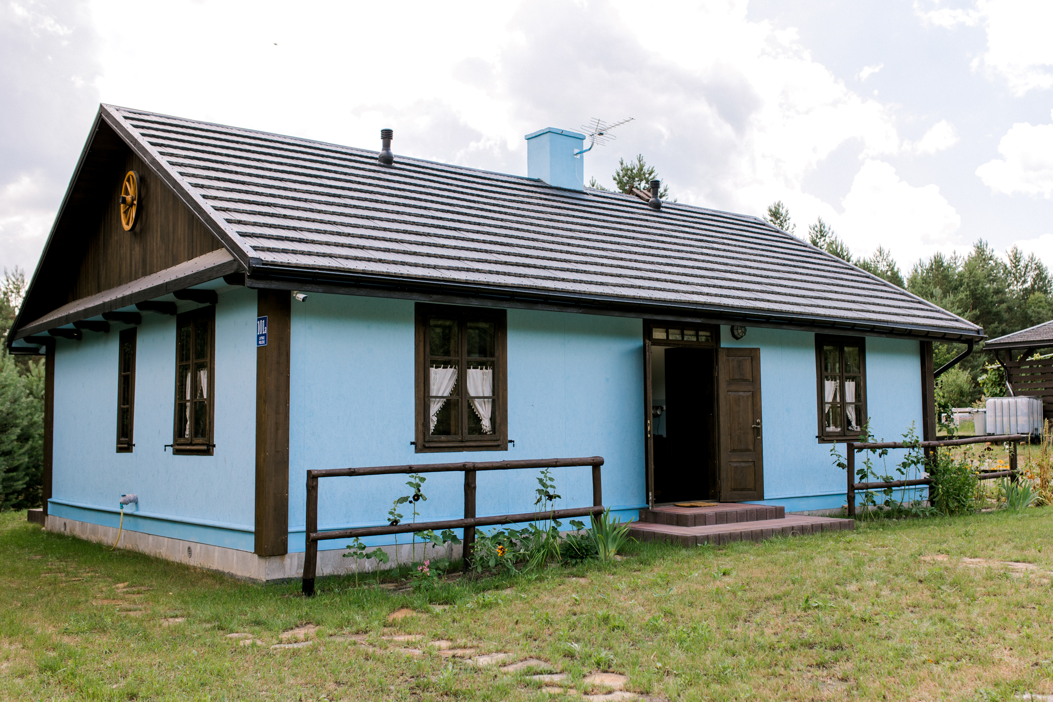 Niebieska tradycyjna chata wiejska z drewnianym dachem, agroturystyka Polska, domki na wynajem na wsi