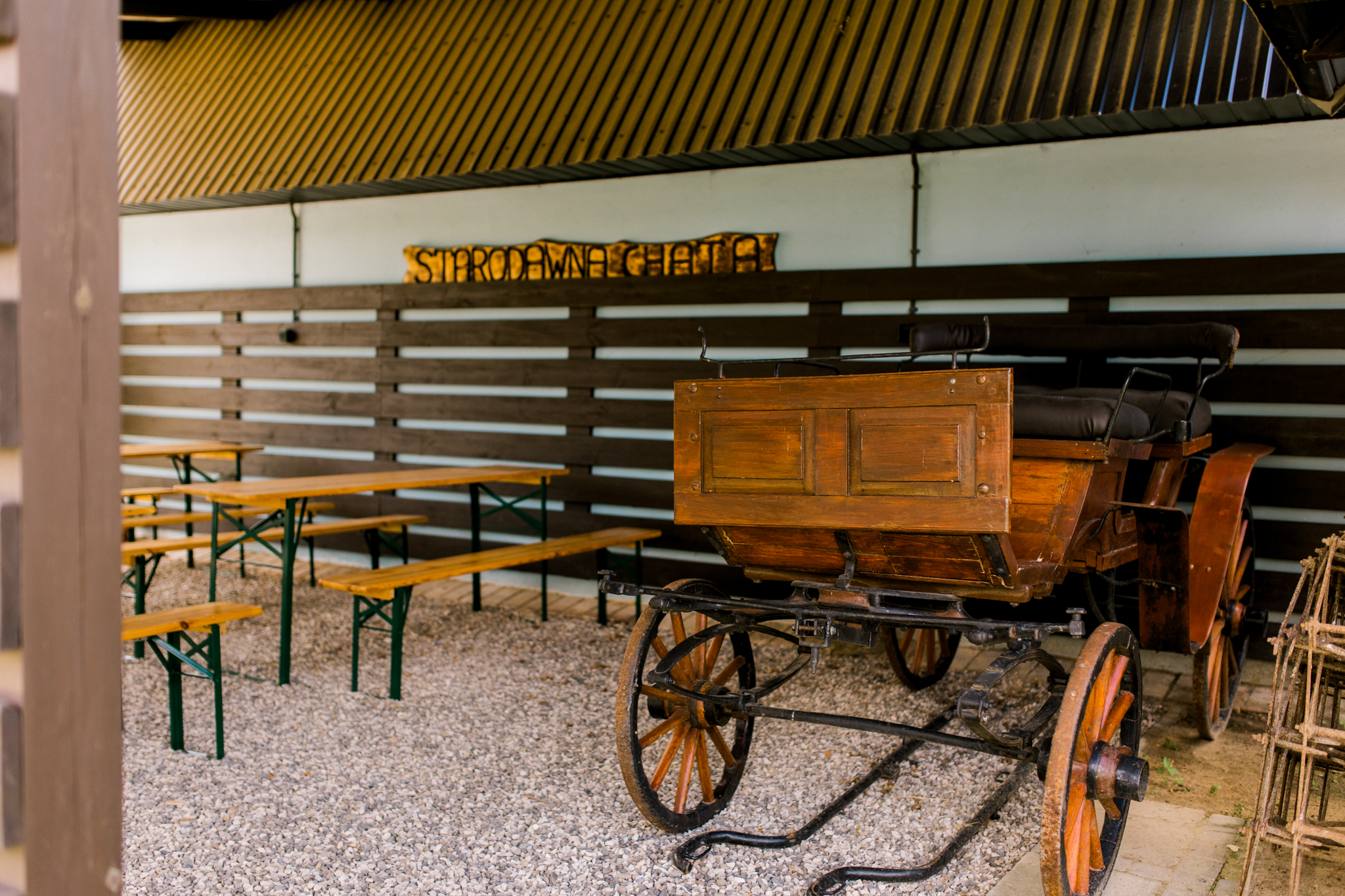 Zabytkowy wóz konny i stoły piknikowe pod zadaszeniem, folklor w agroturystyce Stara Dawna Chata, relaks na wsi Polska