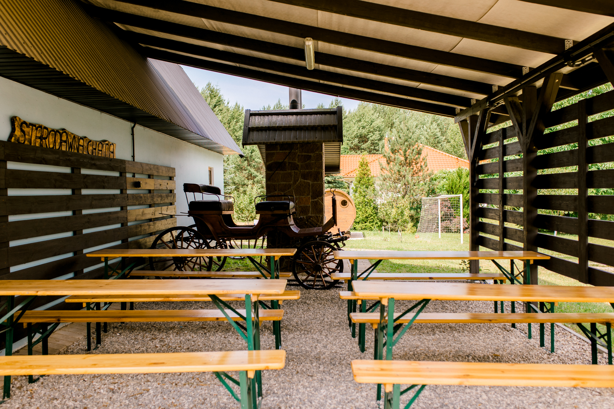 Odkryty taras z stołami i zabytkowym wozem konnym, restauracja w agroturystyce Stara Chata Polska