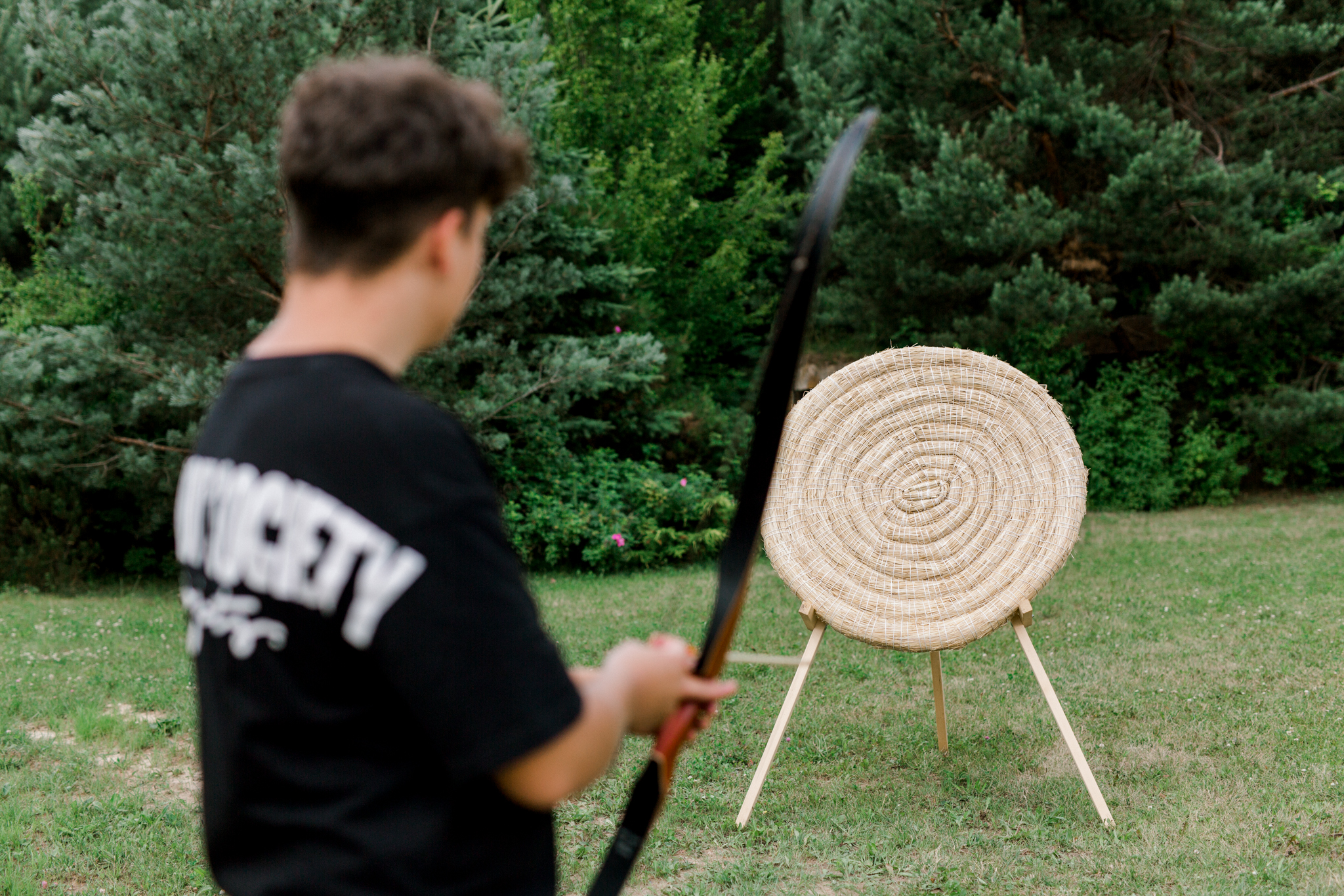 Łucznik przygotowujący strzał do tarczy w zielonym otoczeniu, aktywny wypoczynek w agroturystyce Polska