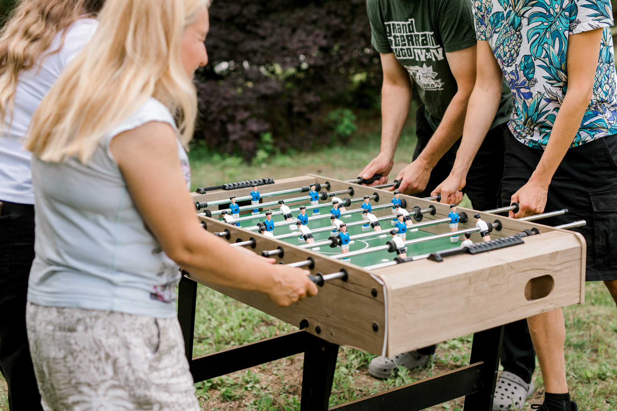 Grupa przyjaciół grających w piłkarzyki na trawie, zabawy grupowe w agroturystyce, wakacje rodzinne Polska